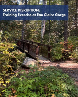 "Service Disruption: training exercise at Eau Claire Gorge" over trail with wooden bridge